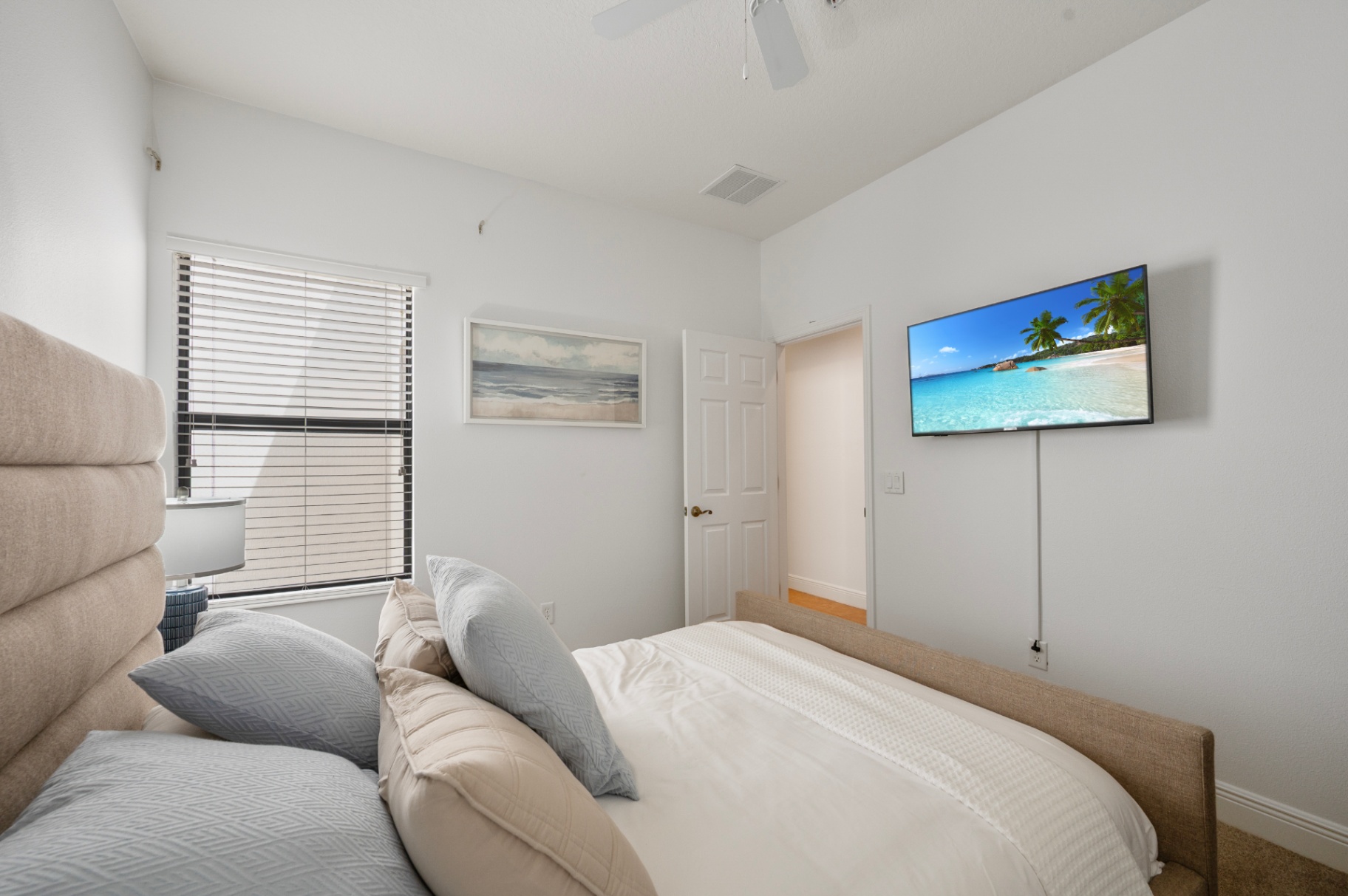 Guest bedroom view toward the television wall and hallway door