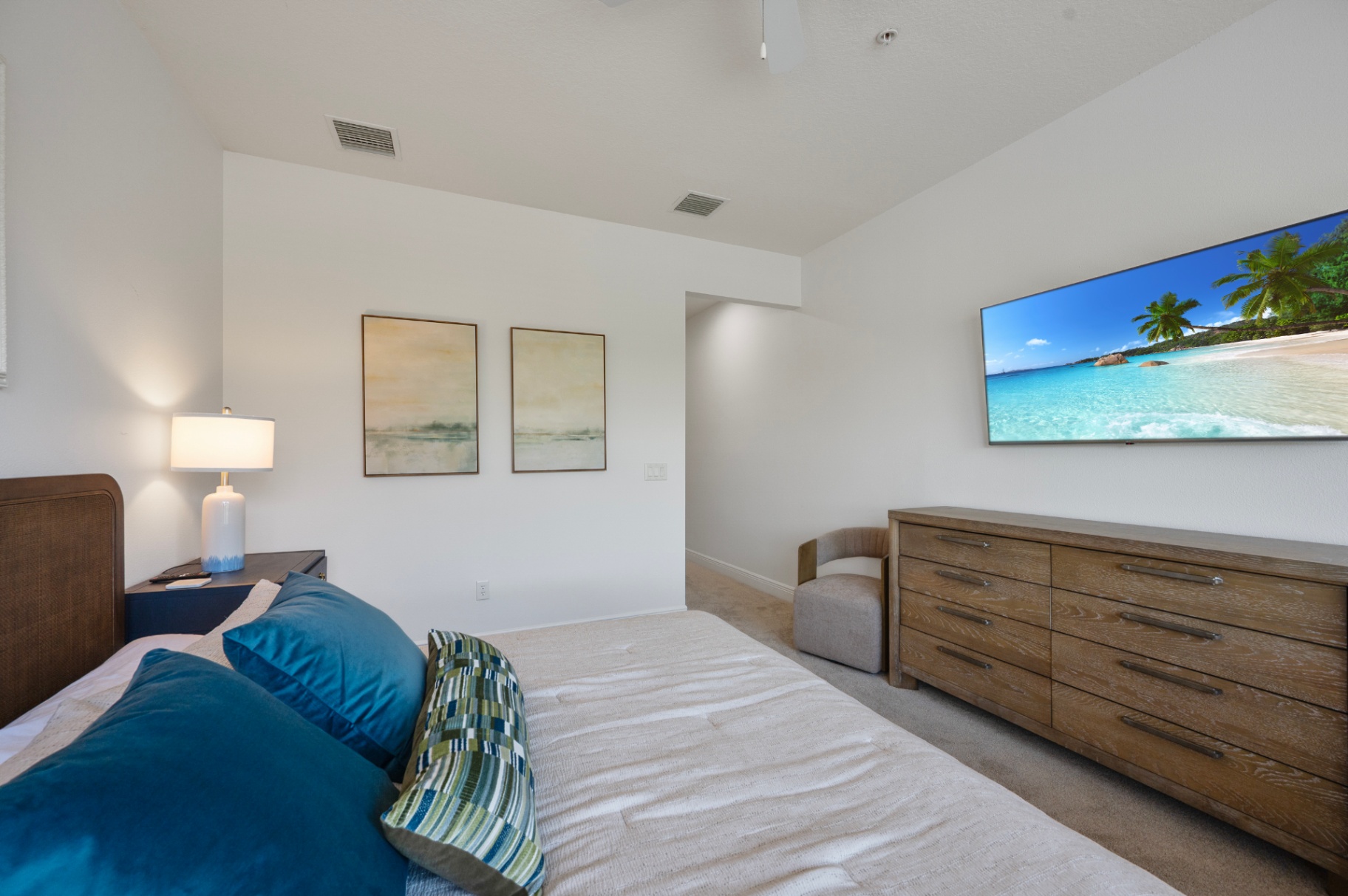 Bedroom with dresser, television, and upholstered chair