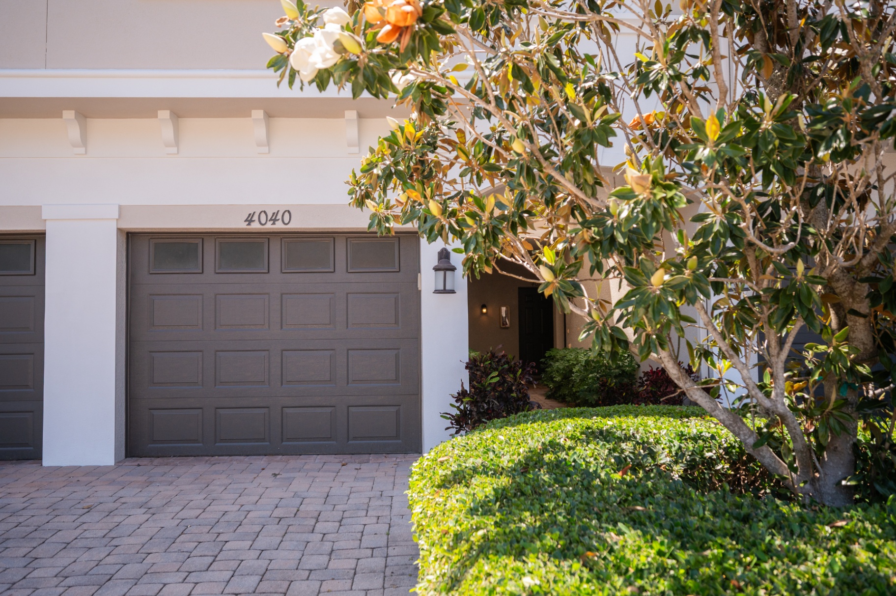 Private garage and front approach framed by mature landscaping