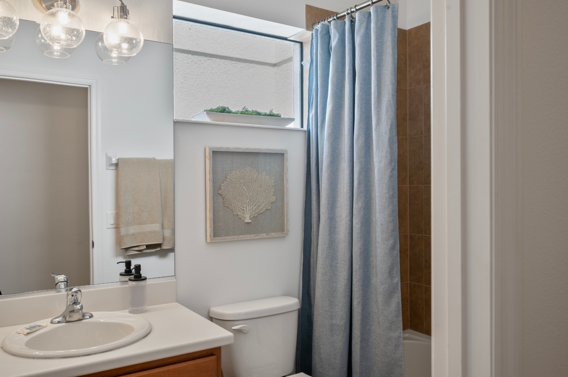 Full bathroom with vanity, toilet, and blue shower curtain