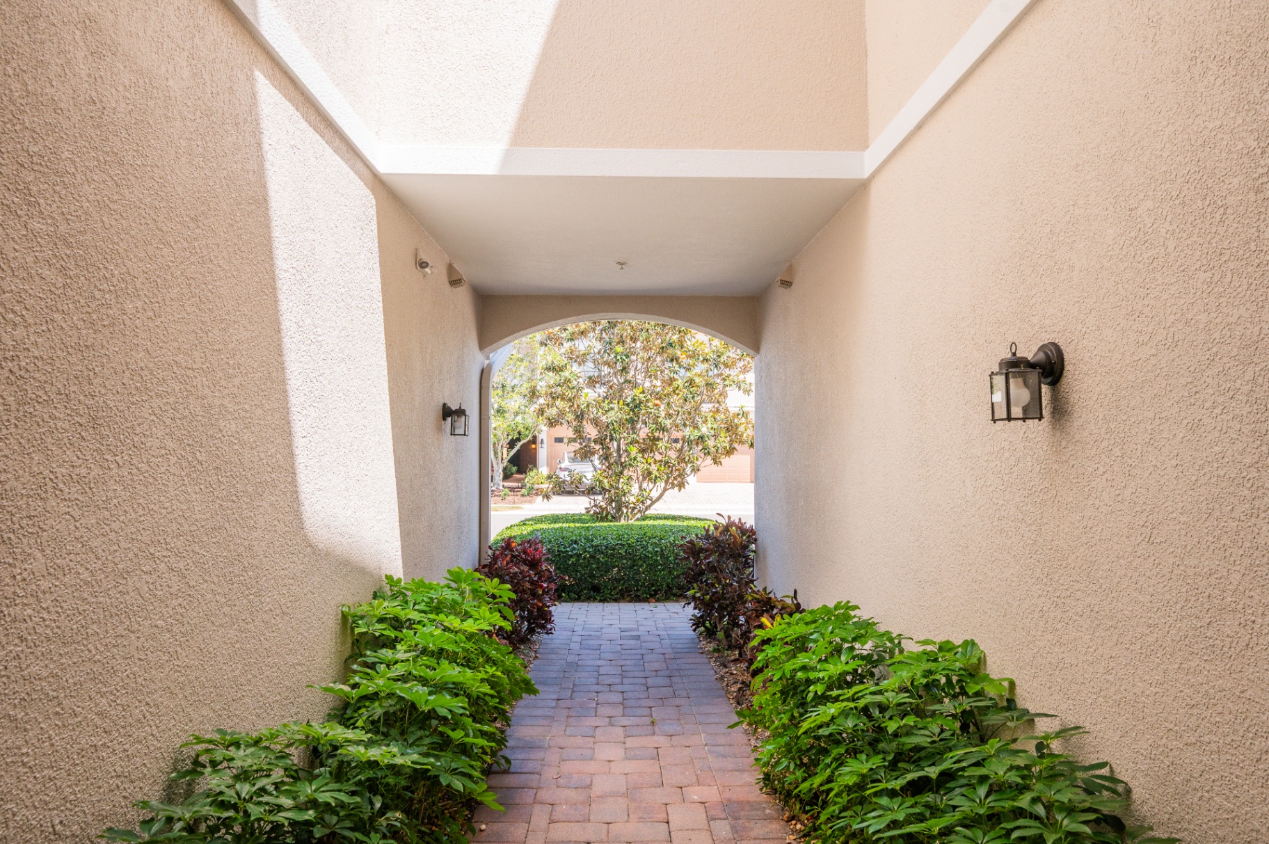 Covered breezeway and landscaped entry walk leading toward the home