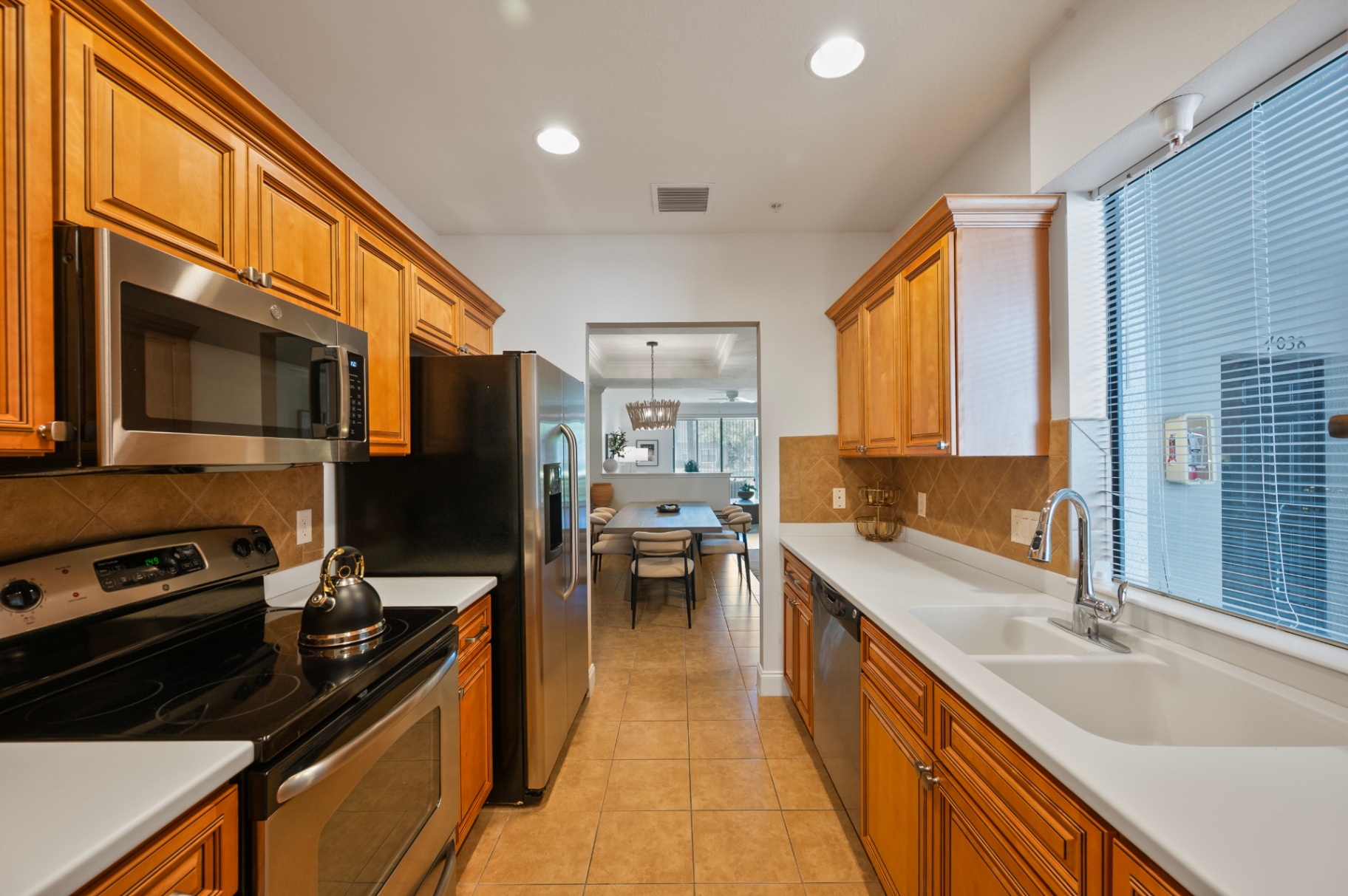 Kitchen with full-size range, refrigerator, and long sink counter