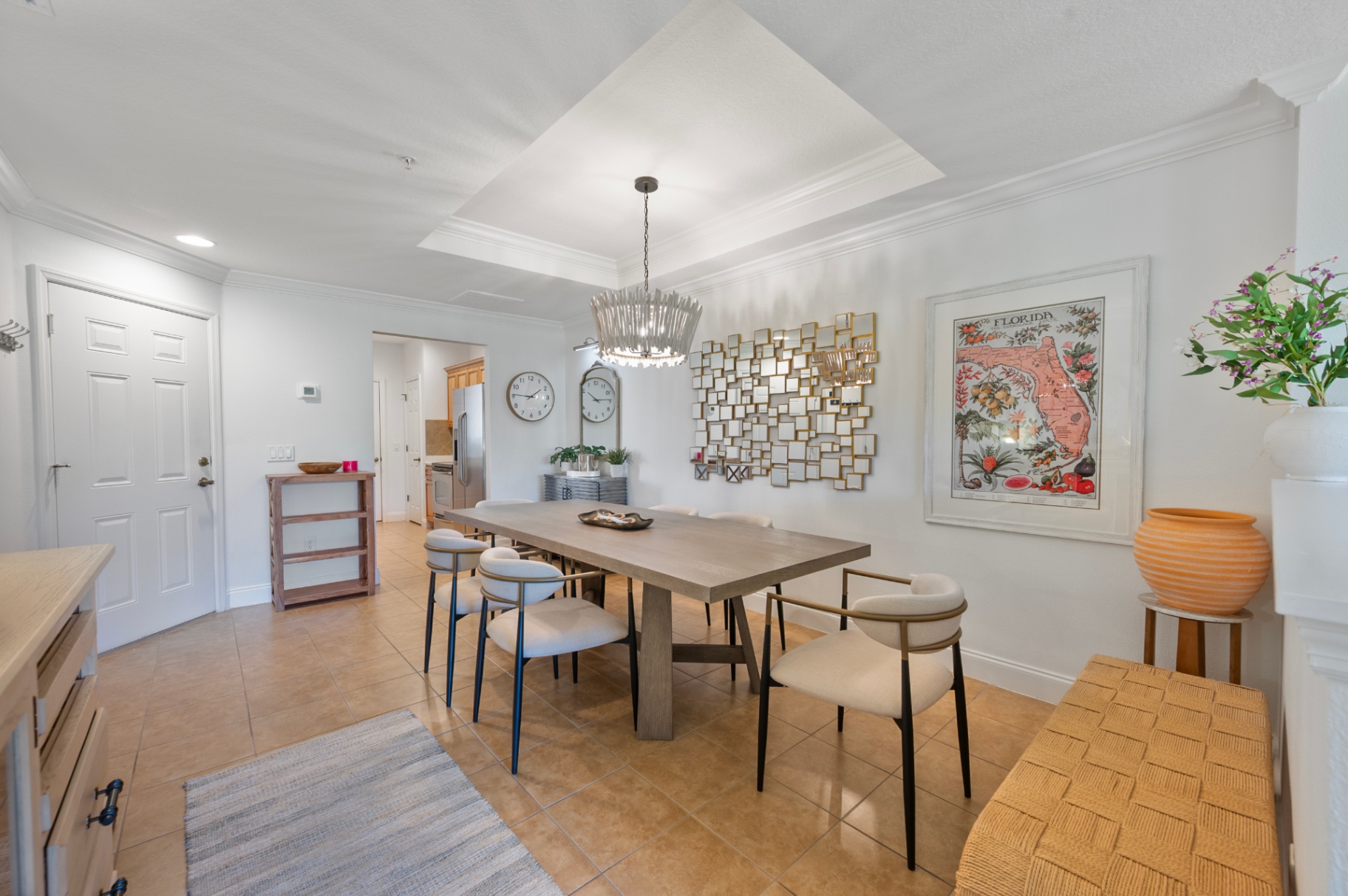 Dining room with large table, statement lighting, and Florida artwork