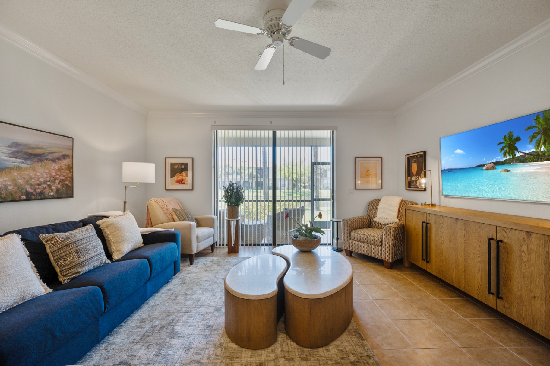 Living room with sofa seating, television, and sliding doors to the lanai